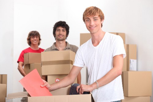 A grand piano being prepared for removal by trained movers